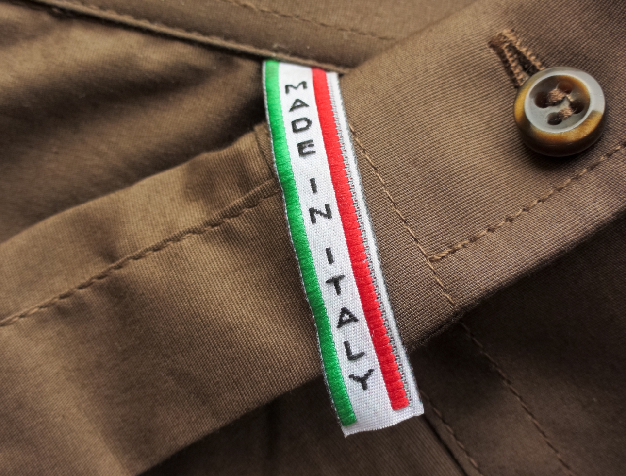 Made in Italy label applied to sartorial fabric, custom processing detail.